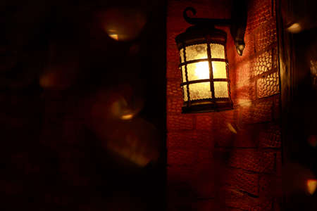 Lantern hanging on hook a brick wall