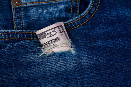 Fifty dollars banknote in a hole of jeansの写真素材