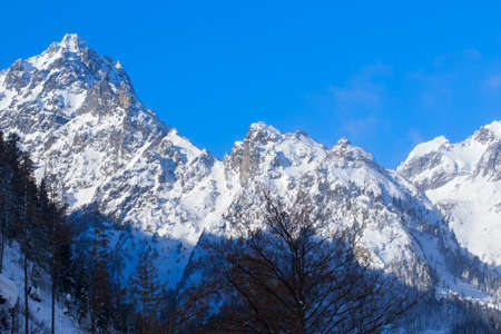 Panorama of beautiful snowy mountains against the blue skyの写真素材