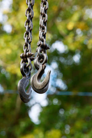 Crane hooks for lifting goods on the background of green leavesの写真素材