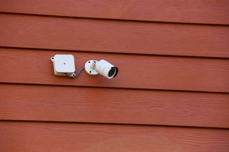The surveillance camera on a wooden background