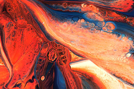 Abstract background of acrylic paints in orange and blue color tones