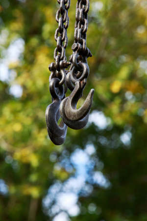 Crane hooks for lifting goods on the background of green leavesの写真素材