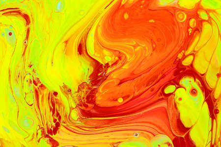 Abstract background of acrylic paints in orange and green color tones