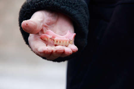 The false teeth in old male handsの写真素材
