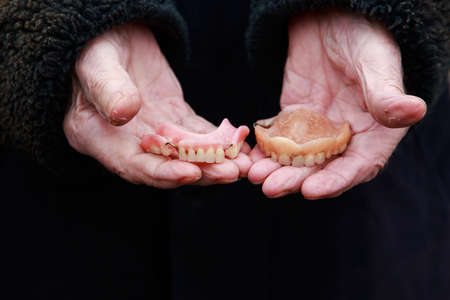 The false teeth in old male hands