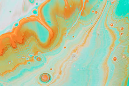 Abstract background of acrylic paints in aquamarine and orange color tones