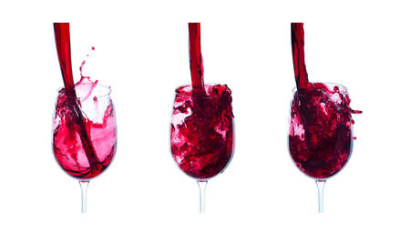 red wine is poured into a glass on the white backgroundの写真素材