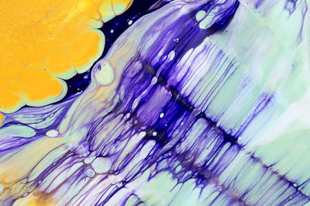 Abstract background of acrylic paint in yellow and purple tones