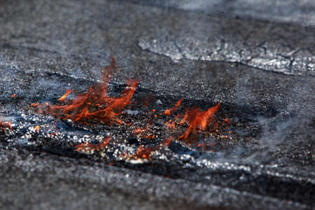 Fire on the background of roofing materialの写真素材