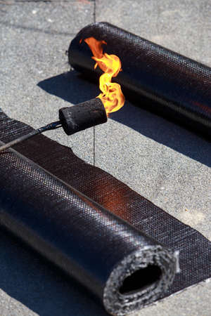 Roll of roofing material with a gas burner
