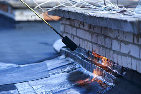 Gas burner with fire on the background of roofing materialの写真素材