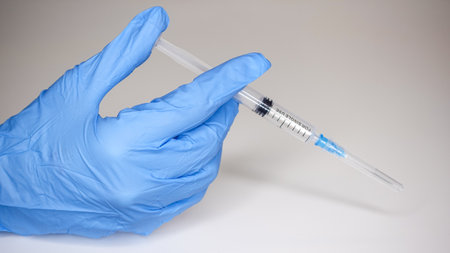 Hands in gloves and with a medical syringeの写真素材
