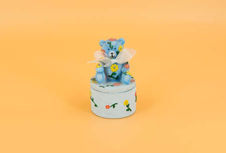 Teddy bear with a bow sits on a casketの写真素材