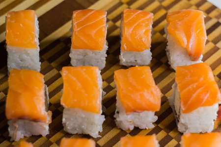 The set of salmon rolls on bamboo board. Focus on top lineの写真素材