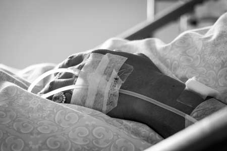 black and white Close up of a old man patient in hospital with saline intravenous (iv)