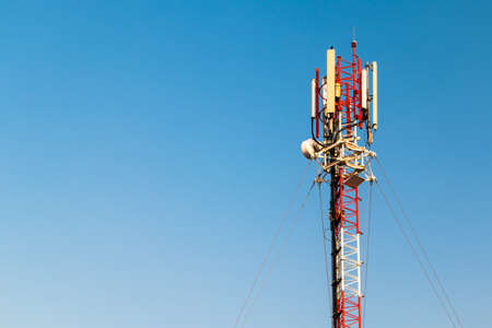 Close up  color antenna repeater tower on blue skyの写真素材
