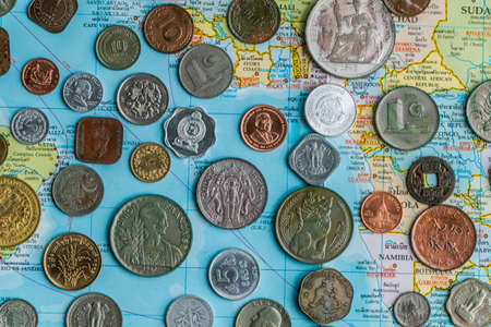 Many silver and golden coins on travel map.の写真素材