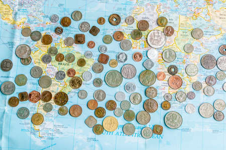 Many silver and golden coins on travel map.