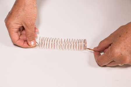 Hand try to pull Spiral spring on white background