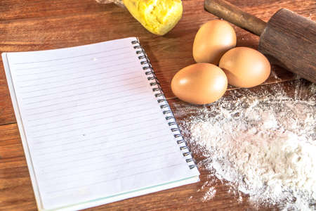 Ingredients for baking - flour, egg, cookie cutters on wooden background.
