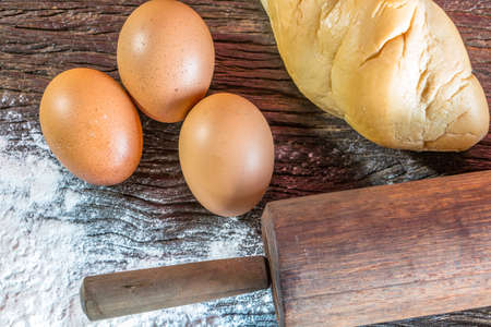 Ingredients for baking - flour, egg, cookie cutters on wooden background.
