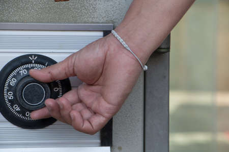 Hand unlock the silver safe box at room.の写真素材