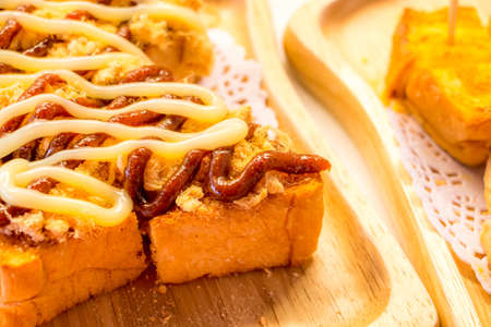 Bread topped with mayonnaise and tomato sauce dried shredded pork put on wooden plate.の写真素材
