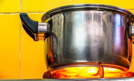 Boiling spaghetti in pan on electric stove in the kitchen.の写真素材