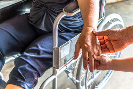 Person sit on wheelchair, Kid encourage to mom injured sit on wheelchair.の写真素材