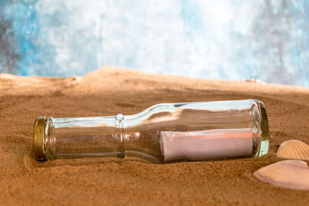 bottle with a message in the sand on the beach.の写真素材