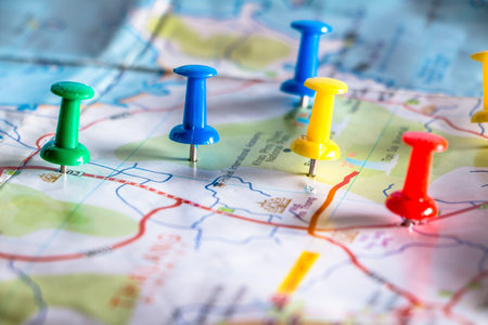 Travel destination pin points on a map with colorful thumbtacks and depth of field with select...