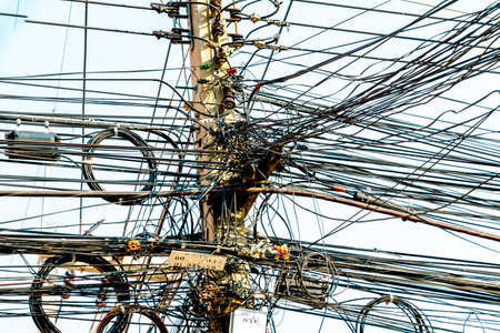 Electric Power lines are not working on a power pole tangled messy in city of Thailand.の写真素材