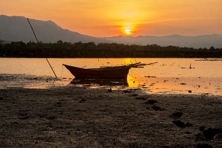silhouette fishing boat and sunset in Thailandの写真素材