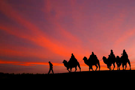 great sky and caravan travelers riding camelsの写真素材