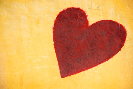 red heart painting on cement wall background.の写真素材