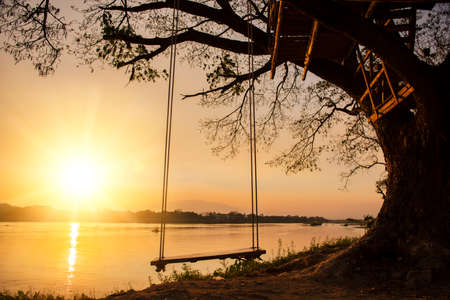lone swing at river side and sunset ,Thailandの写真素材