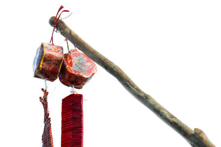 The red chinese fire crackers for celebration day hanging on branch isolated on white.