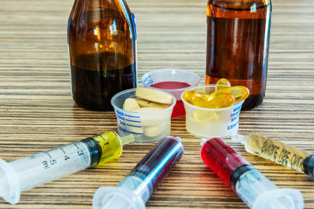 Syringe with syrup medicine and pill use to feed for kids.の写真素材