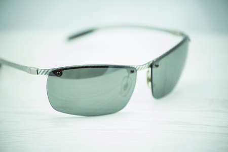 Carbon fiber sun glasses on wooden table.