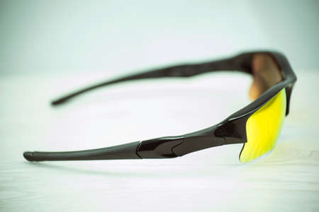 Orange sun glasses on the wooden table.の写真素材