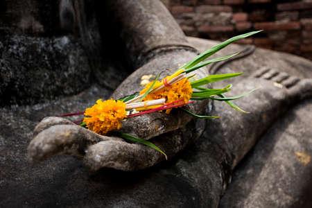 Close up flower on hand of buddha statue at Sukhothai historical park. Srichum Temple ,Thailand.の写真素材