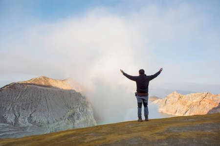 Man standing at Kawah Ijen Crater at sunrise panoramic view, Indonesia.の写真素材