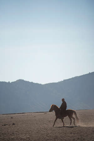 Horse rider on desert near Bromo Mountain Java ,Indonesia.の写真素材
