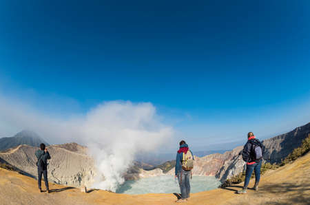 Tourists taking photograph at Kawah Ijen Crater at sunrise panoramic view, Indonesia.の写真素材