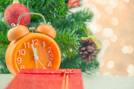 Christmas present celebration time orange clock and christmas tree.の写真素材
