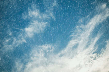 Falling snow with dramatic sky background.の写真素材