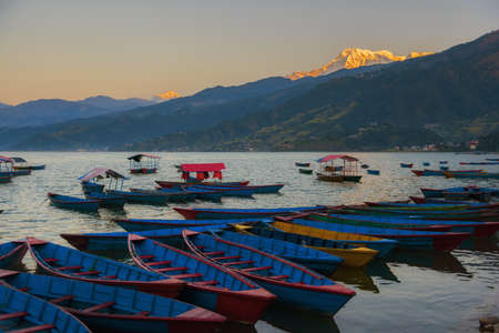 Sunrise with wooden boats on Phewa lake, Pokhara, Nepalの写真素材