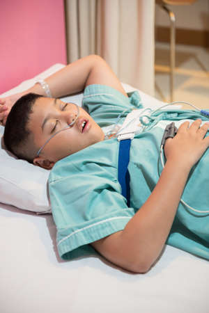 Asian boy wearing Sleep Apnea Diagnostic medical device Kit. Sleep Lab Test.