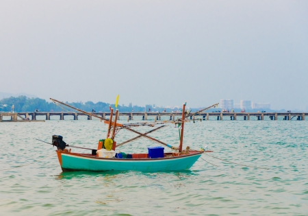 Blue fishing boat on sea and bridge backgroundの写真素材